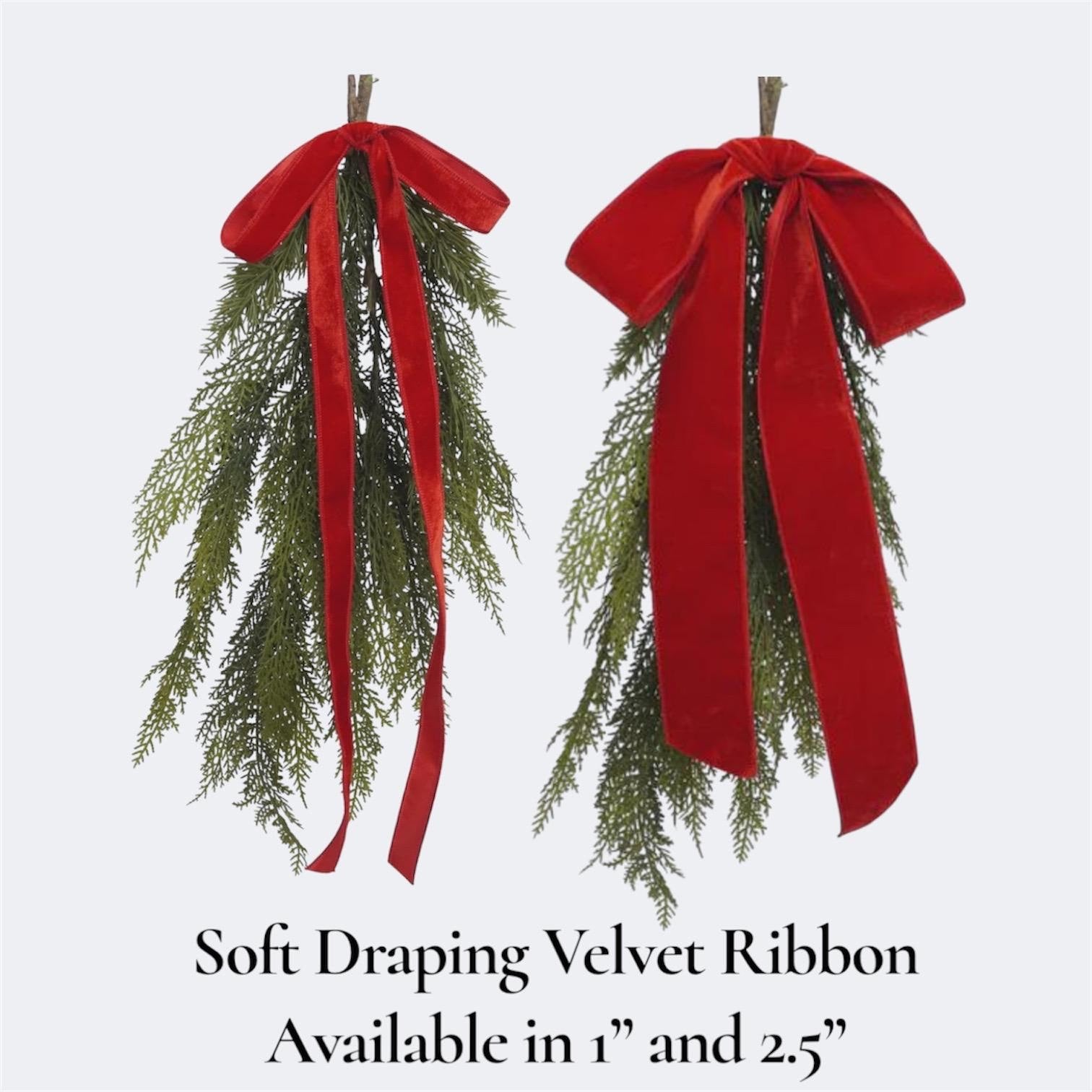 Two green evergreen garland sprigs with long red velvet ribbon bows, shown on a light gray background with text reading 'Soft Draping Velvet Ribbon Available in 1" and 2.5"'.