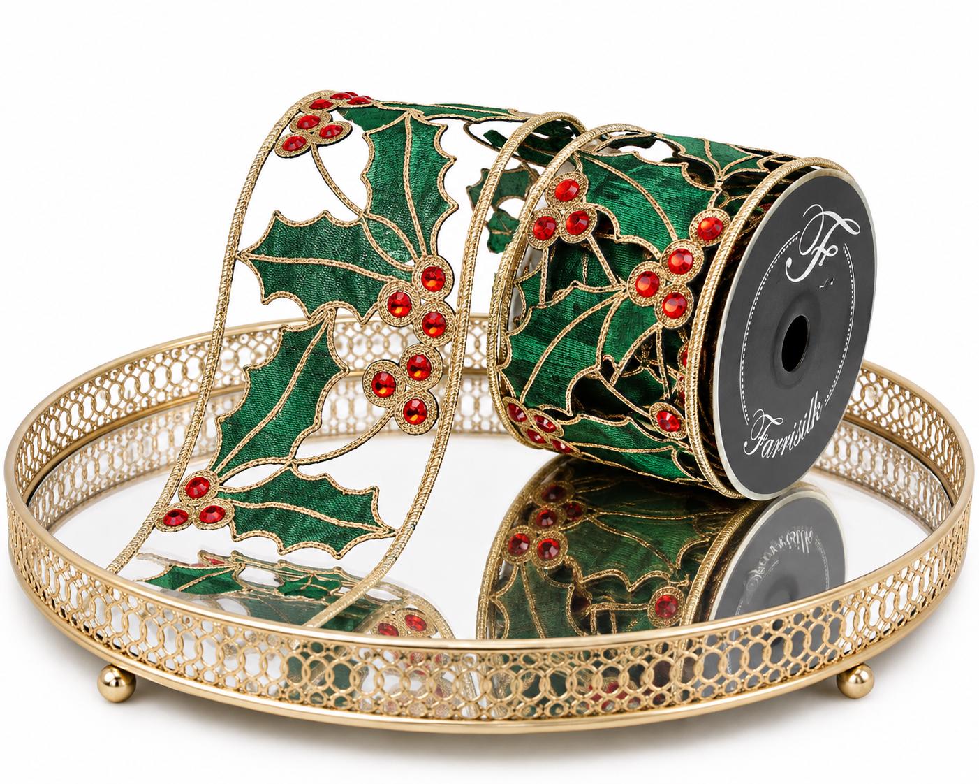 Green holly wired Christmas ribbon with red jeweled berries displayed on a decorative gold tray
